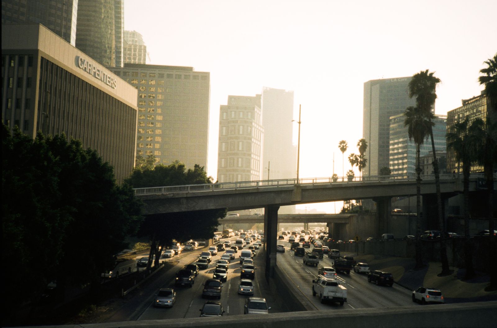 Heavy traffic on a Los Angeles freeway at sunset with the downtown skyline
